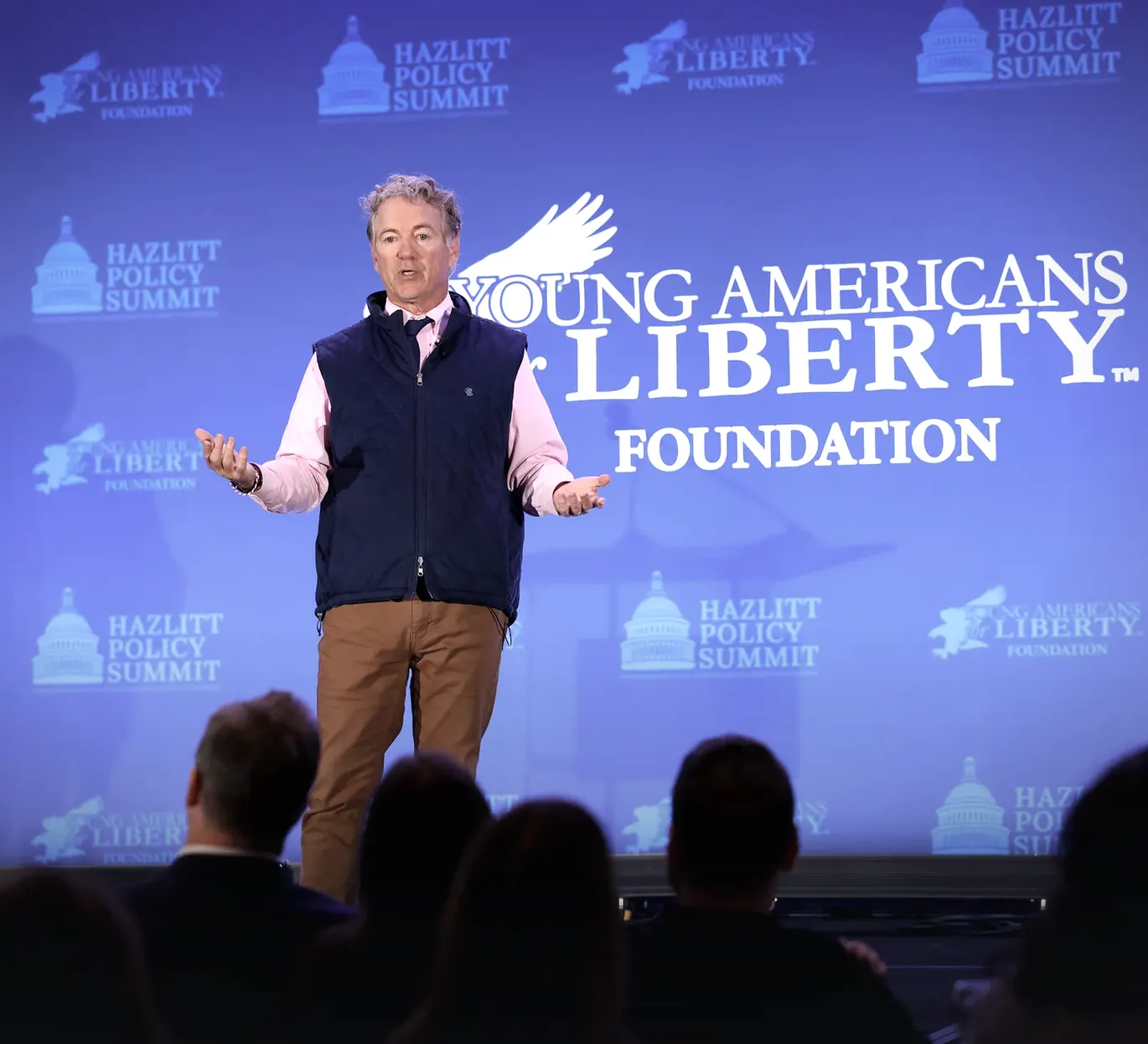 Senator Rand Paul speaking on stage at the 2024 Hazlitt Policy Summit, in front of a Young Americans for Liberty Foundation backdrop.